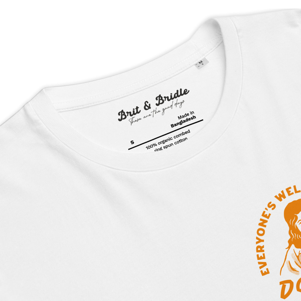 Close-up of a white short-sleeve t-shirt showing the inner neck label with 'Brit & Bride' branding and a partial orange graphic print on the right side.