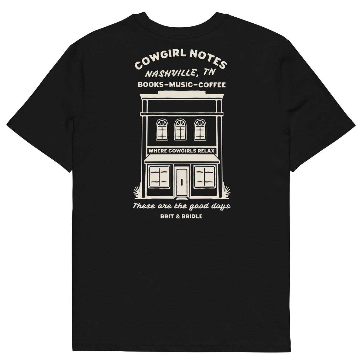 A black short-sleeve t-shirt with a white graphic print on the front depicting a storefront building and text reading 'COWGIRL NOTES NASHVILLE, TN BOOKS - MUSIC - COFFEE' and 'These are the good days BRIT & BRIDLE'.
