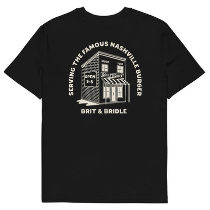 A black short-sleeve t-shirt with a white graphic print on the front. The graphic features a brick diner building with the text 'SERVING THE FAMOUS NASHVILLE BURGER' arched above it and 'BRIT & BRIDLE' printed below.