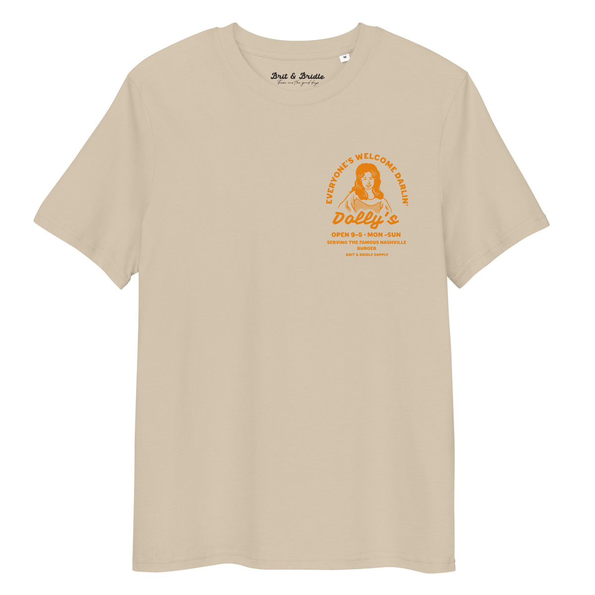 A beige short-sleeve t-shirt with a vintage-style orange graphic on the left chest. The graphic features a portrait of a woman and the text 'Dolly's' along with business hours.