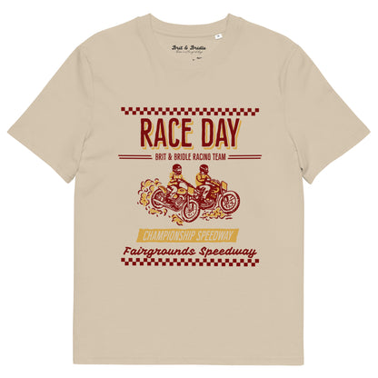 A beige crewneck t-shirt featuring a vintage-style racing graphic on the front with the text 'RACE DAY', 'BRIT & BRIDLE RACING TEAM', and 'Fairgrounds Speedway' in red and yellow.